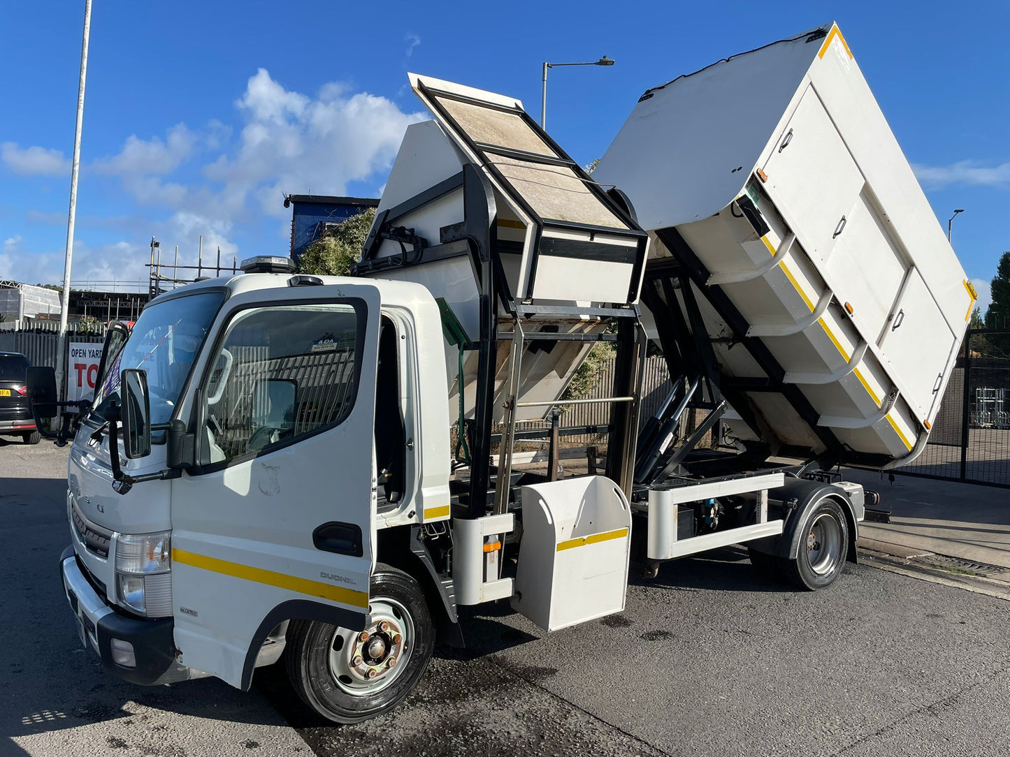 White tipper truck with open cargo area on a road
