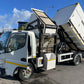 White tipper truck with open cargo area on a road