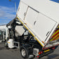 Garbage truck with open rear door on a street